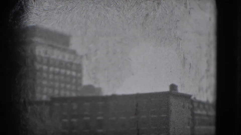 Grainy 1975 Washington DC home-movie frame with the main building partly cropped, foreground rooftops, and a small rooftop structure.