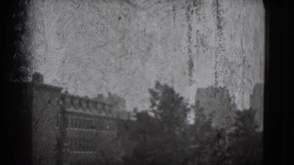 1975 Washington DC home-movie frame with hazy distant buildings, trees, and dark window-like framing on black-and-white 8mm film.