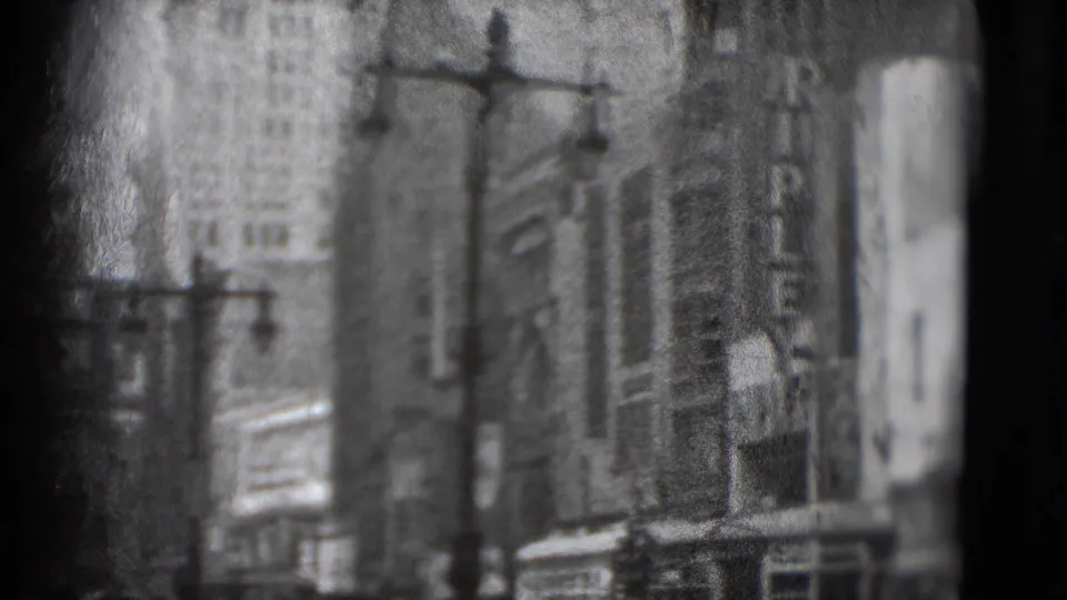1975 Washington, DC 8mm frame showing tall downtown facades, streetlamps, and indistinct signage in soft focus.