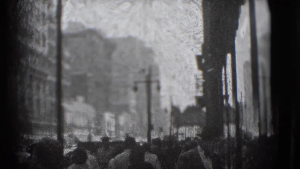 1975 Washington, DC frame showing pedestrians on a crowded sidewalk, vehicles in the street, and tall urban buildings.