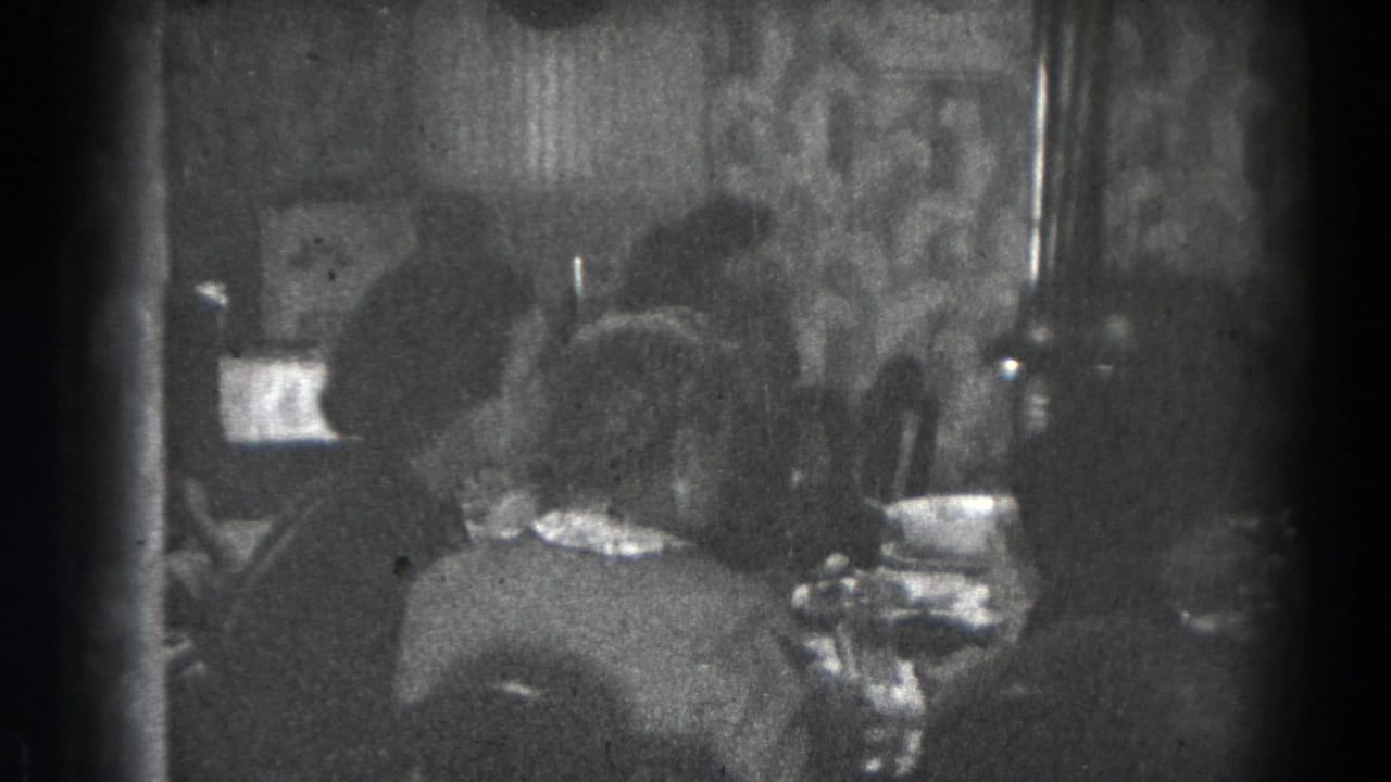 Back view of women seated at a dining table with dishes and glassware.