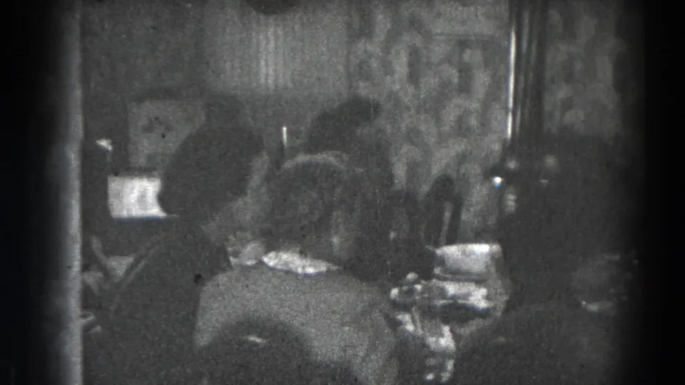 Women sit at a set table in a private Lincoln, Nebraska room, with soft focus and heavy 8mm grain.