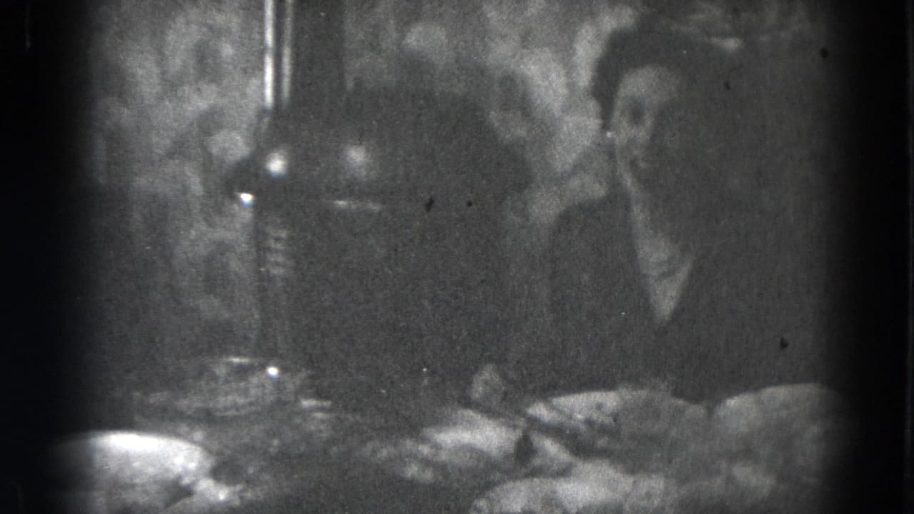 People seated around a table with dishes under hanging lights.