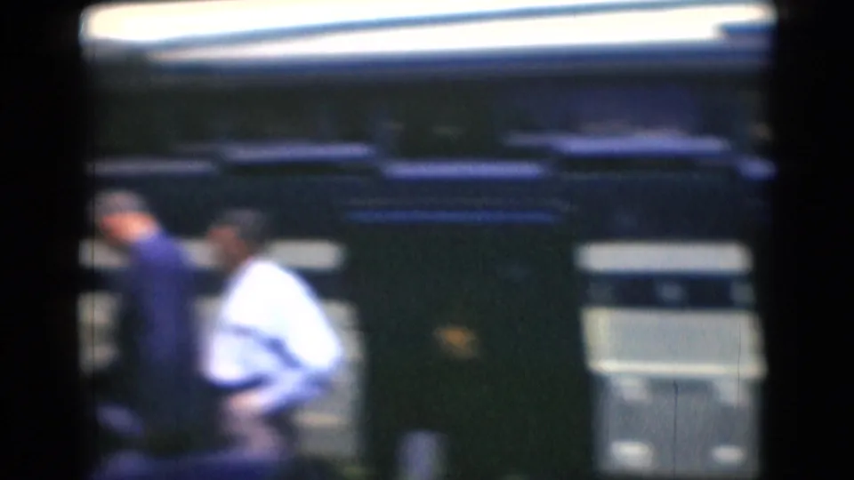 In Middletown, Pennsylvania home-movie footage, adult men appear near a blue-and-white bus in a soft, grainy 8mm frame.