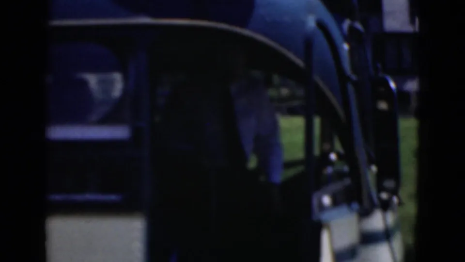 A closer 8mm view shows the open door and side windows of the bus, with an adult man partly visible near the entrance.