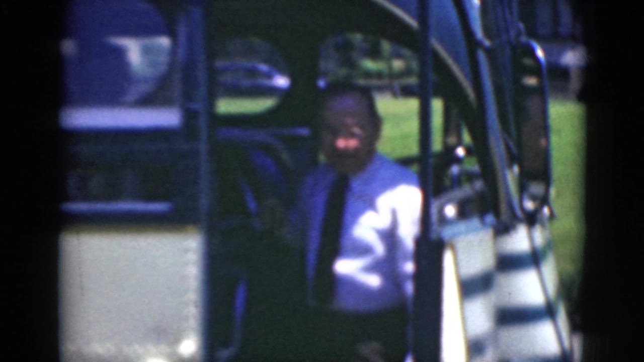 In Middletown, Pennsylvania, a man in a light shirt and tie appears near an antique bus doorway in a soft 8mm frame.