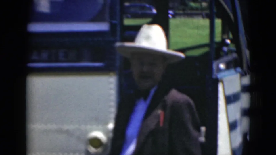In Middletown, Pennsylvania, a man in a white cowboy-style hat stands near the open door of a vintage bus in 1940s 8mm footage.