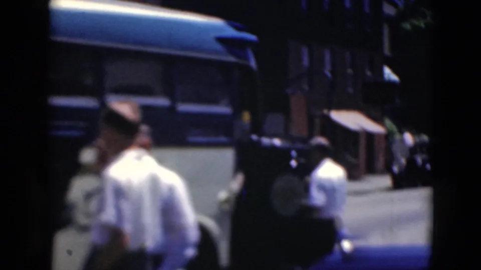 Adult men stand near the side or entrance area of a dark bus in Middletown, Pennsylvania, captured with soft 8mm home-movie focus.