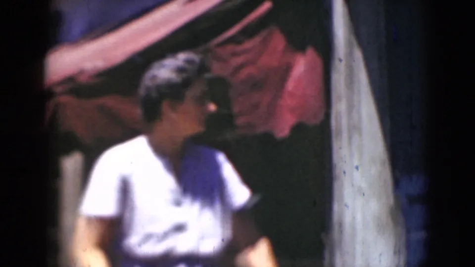 A woman in a light dress appears near a red storefront awning, looking sideways during the brief Middletown street scene.