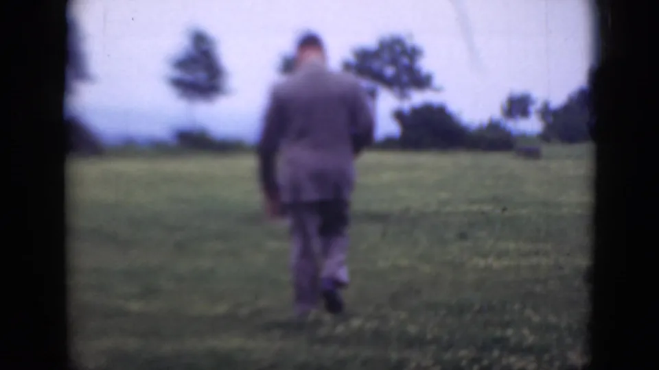 Near the end of the clip, the man appears smaller as he walks away across the Middletown field toward distant trees.