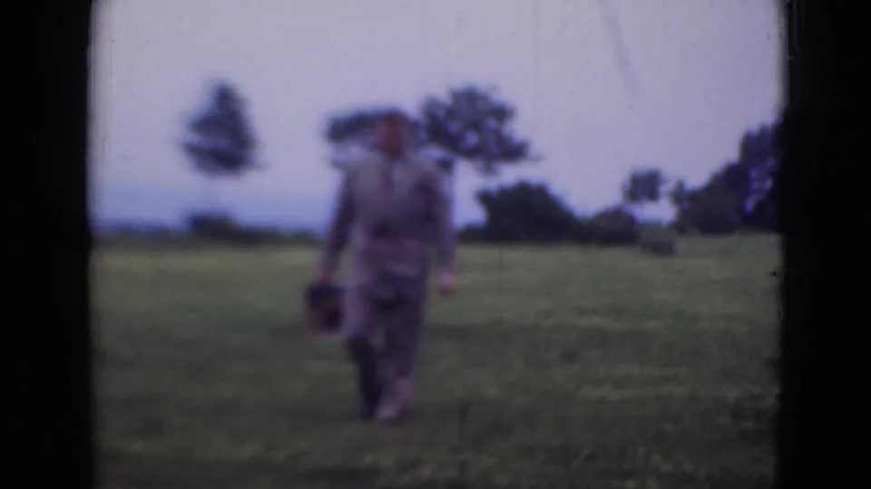 The final frame shows the 1947 Middletown scene with a suited man facing the lens in open grass, holding a dark case.