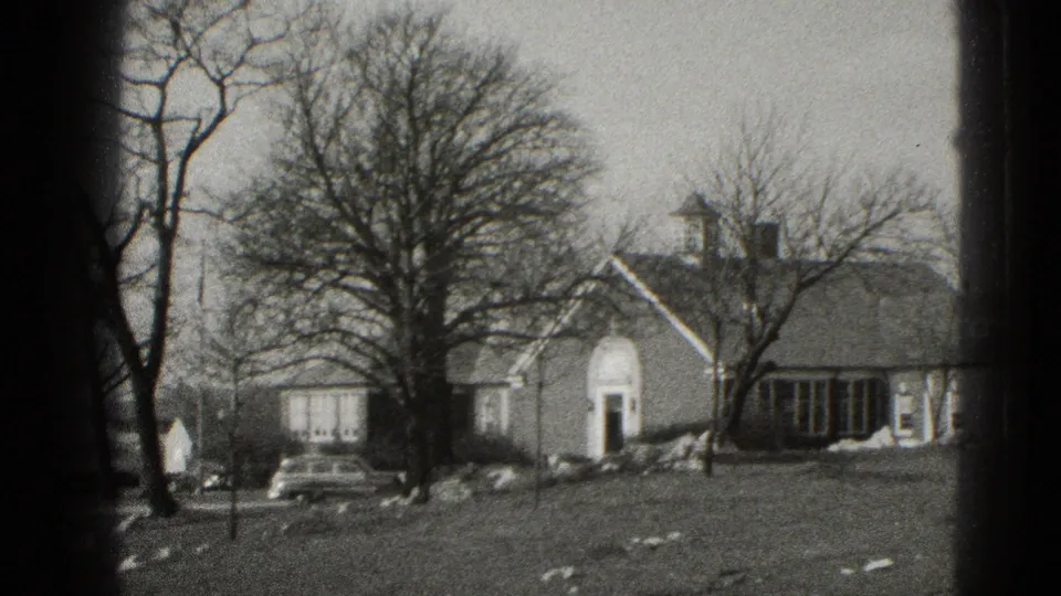 Middletown, Pennsylvania residential exterior with bare trees, arched doorway, lawn, snow patches, and a parked car, from 8mm footage.