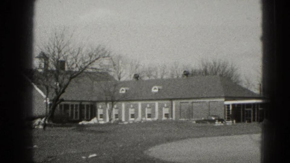 Long Middletown house exterior with dormer windows, bare trees, open lawn, curved driveway, and visible 8mm frame borders.