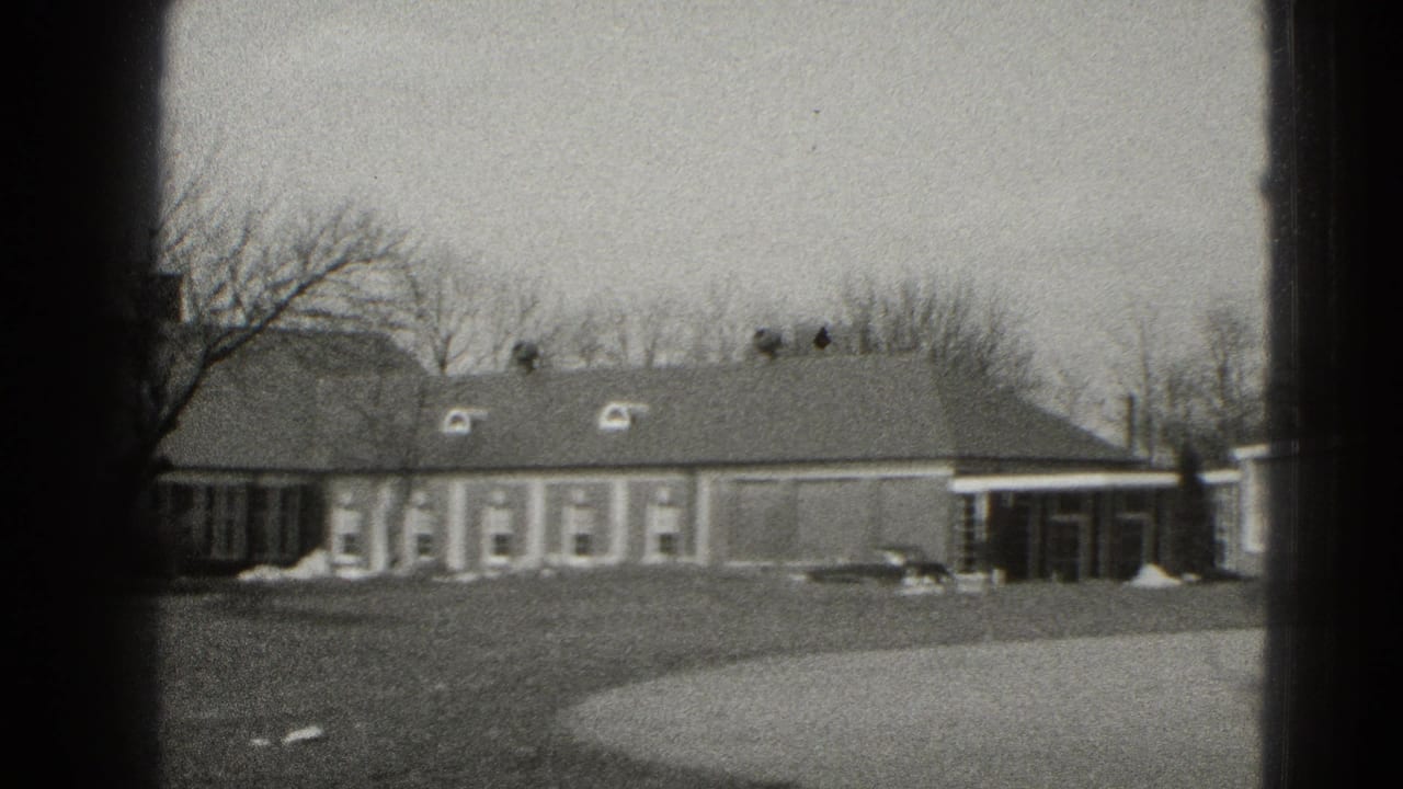 Middletown, Pennsylvania 8mm frame showing a low brick building, bare trees, lawn, walkway, and parked car.