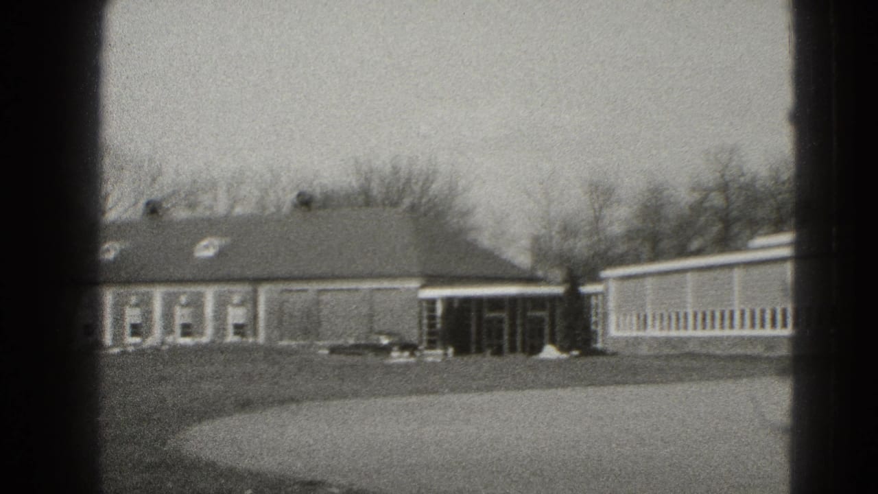 Middletown exterior frame with a low brick building, covered entrance, parked car, bare trees, and open lawn.