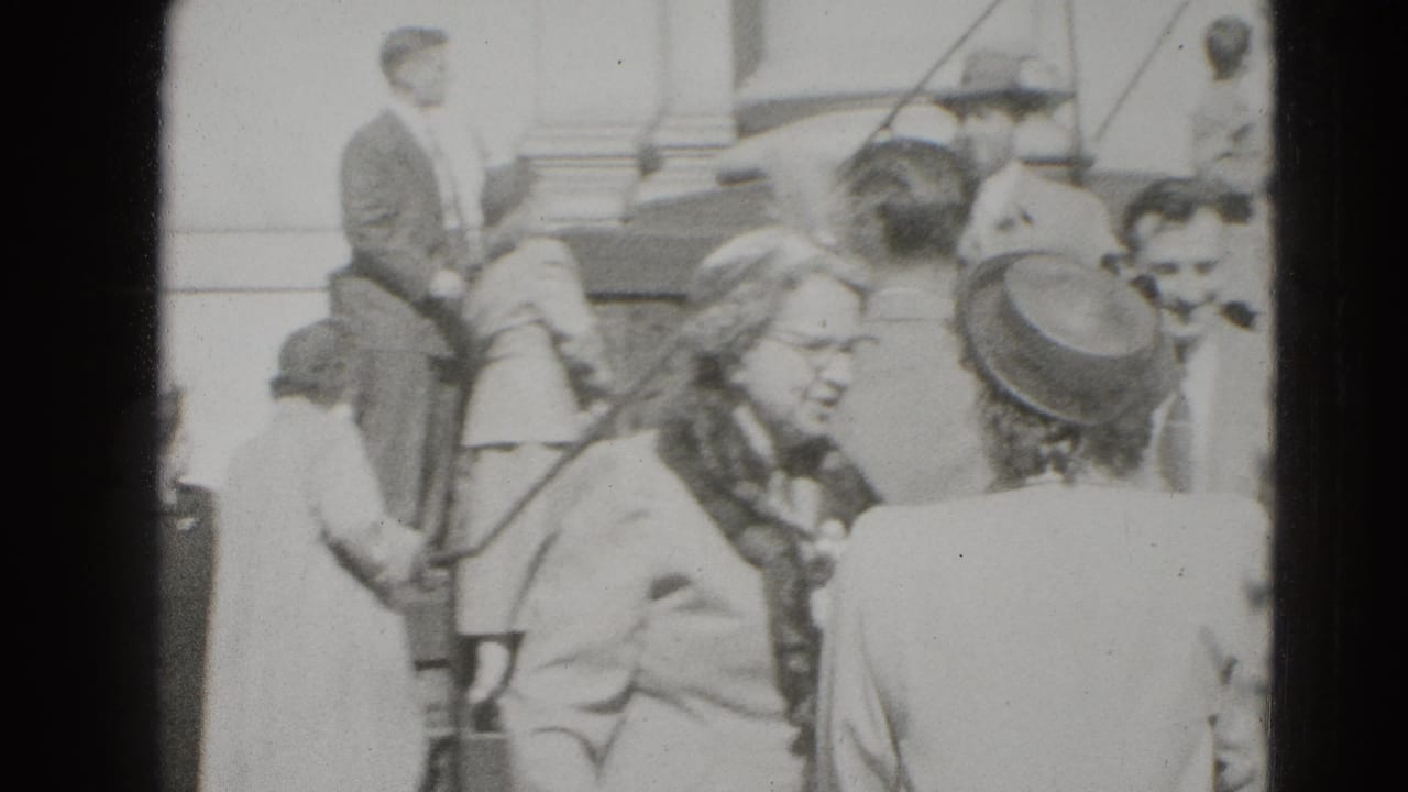 In Middletown, Pennsylvania, guests in coats and hats gather near building steps around a newly married couple.