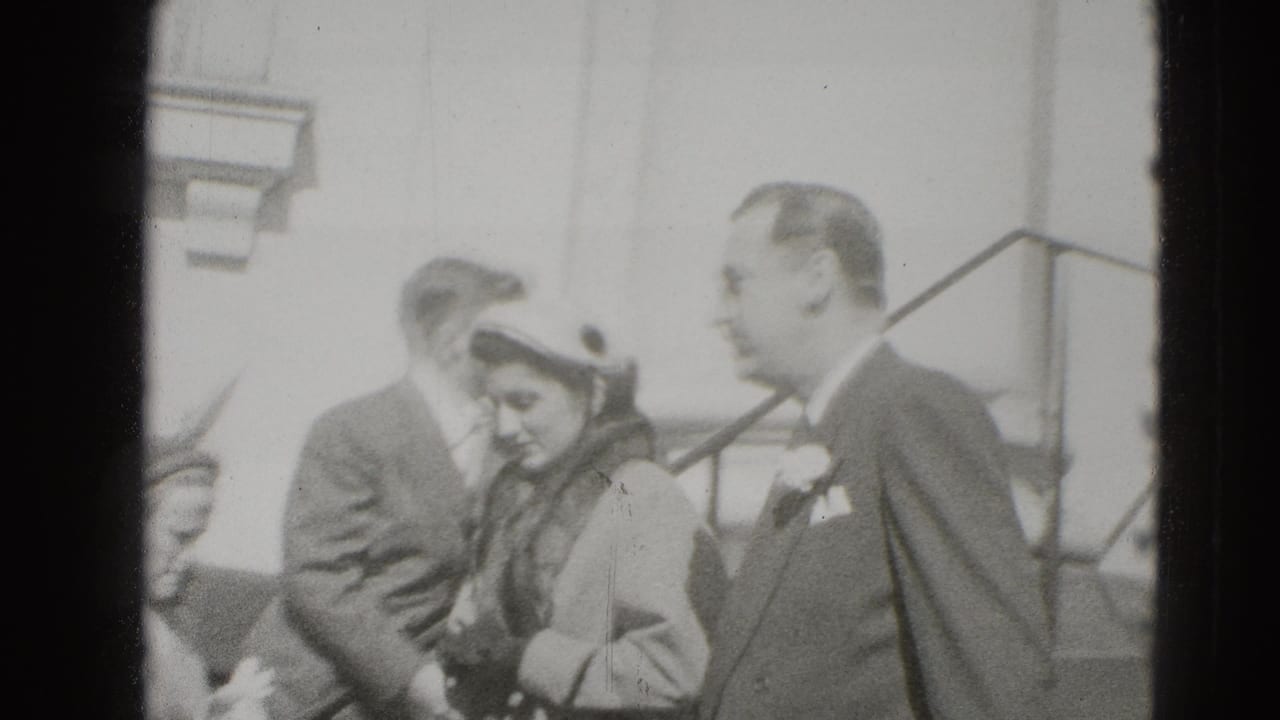 The couple continues down the steps in Middletown, Pennsylvania, with onlookers and a building entrance behind them.