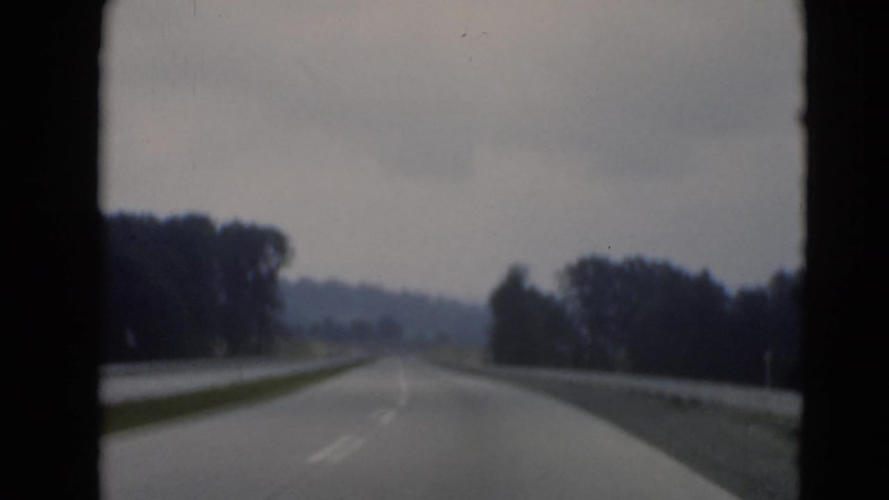 Windshield view of a divided highway near Middletown, Pennsylvania, with lane markings, grassy median, trees, and a distant hill.