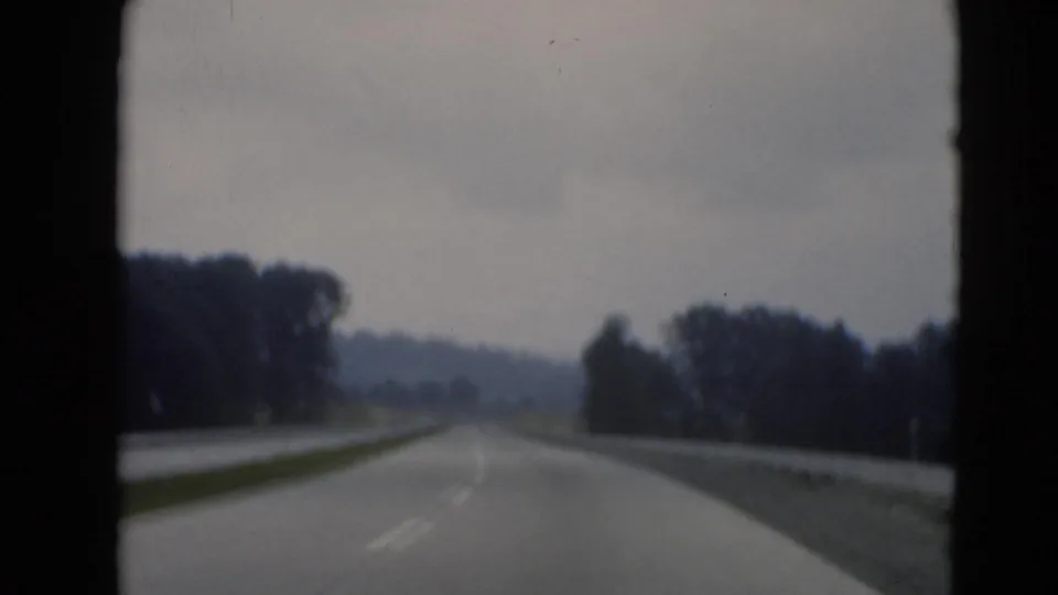 Windshield view of a divided highway near Middletown, Pennsylvania, with lane markings, grassy median, trees, and a distant hill.