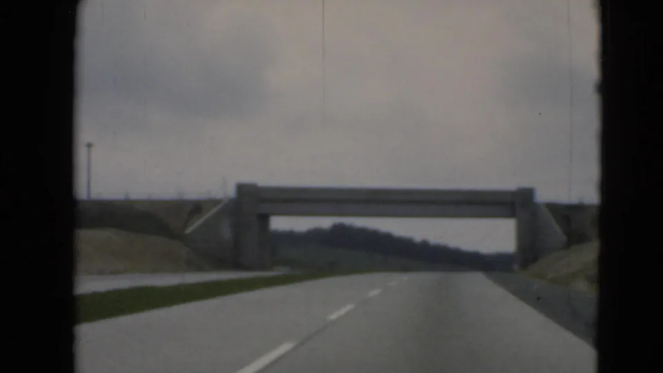 A concrete underpass or overpass crosses the roadway ahead in a driver's-view shot near Middletown, Pennsylvania, with guardrails and hills visible.