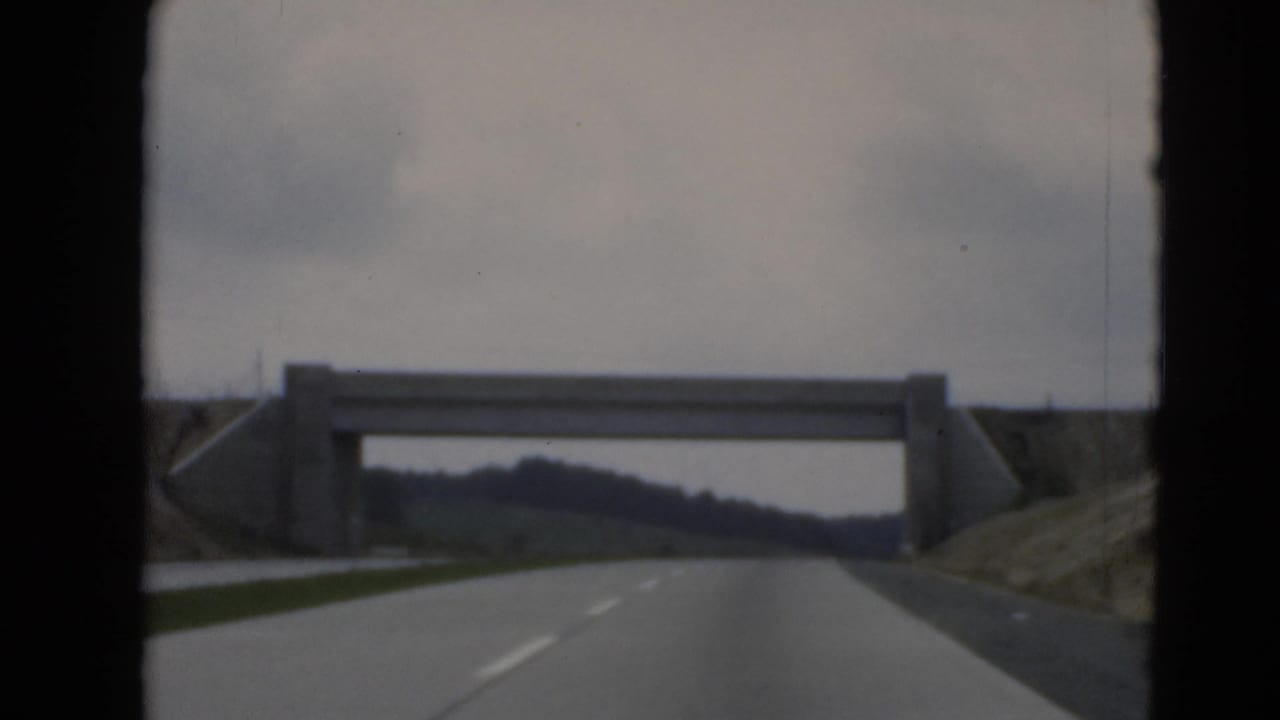 View from a moving car on a rural road near Middletown, Pennsylvania, approaching a concrete overpass.
