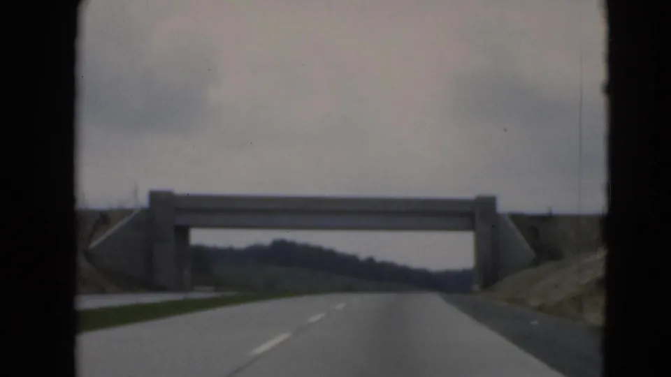 View from a moving car on a rural road near Middletown, Pennsylvania, approaching a concrete overpass.