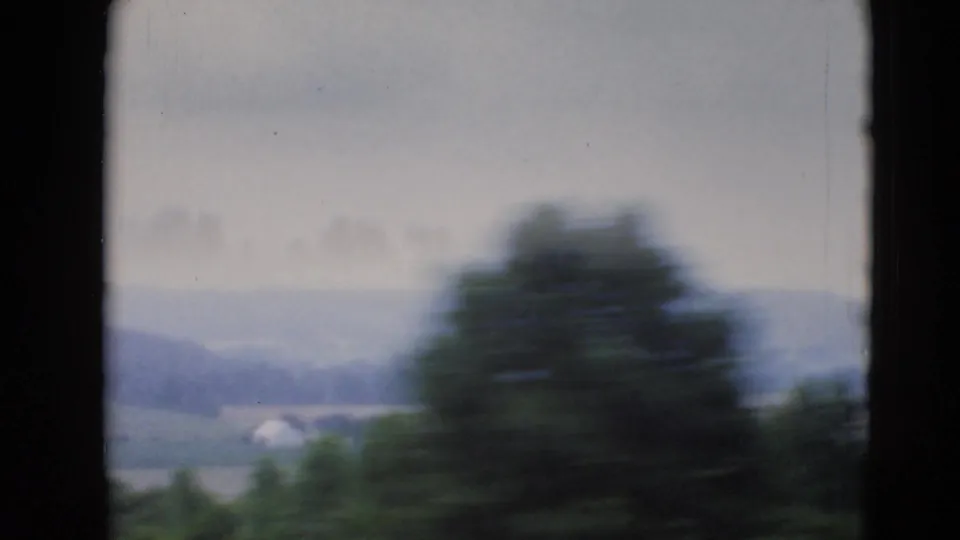 1947 8mm view near Middletown, Pennsylvania, showing blurred trees in front of distant fields and low hills under a pale sky.