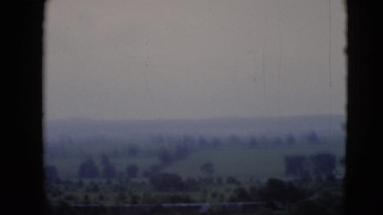 1940s 8mm view from a plane window over hazy hills, fields, and scattered trees near Middletown, Pennsylvania, per supplied metadata.