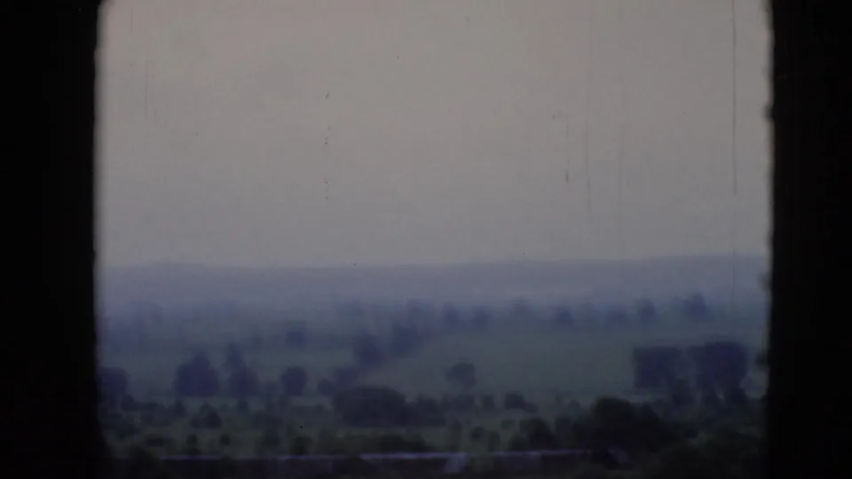 1940s 8mm view from a plane window over hazy hills, fields, and scattered trees near Middletown, Pennsylvania, per supplied metadata.