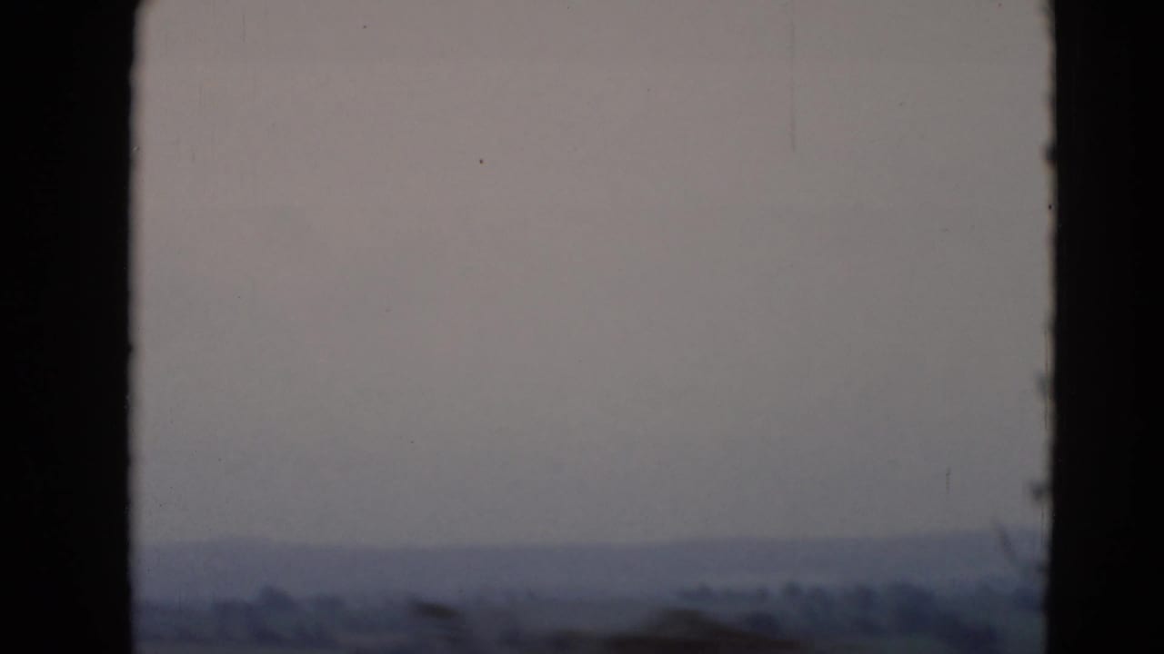 1947 8mm view near Middletown, Pennsylvania, looking through a window toward a hazy horizon, fields, and tree lines.