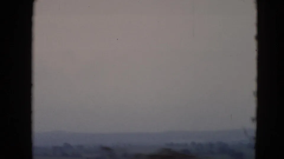 1947 8mm view near Middletown, Pennsylvania, looking through a window toward a hazy horizon, fields, and tree lines.