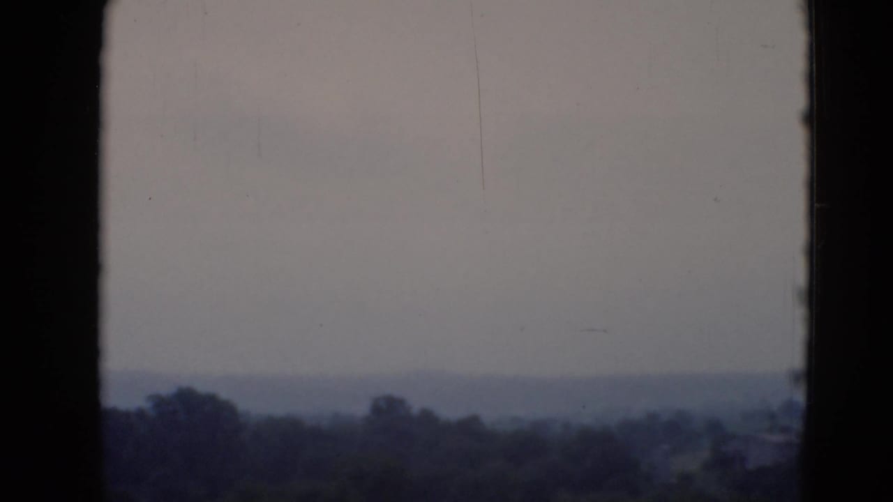 Soft 8mm frame showing a distant wooded Pennsylvania horizon under a pale, hazy sky.