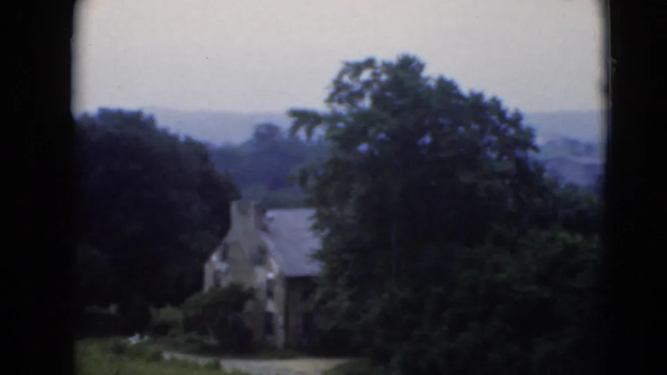 A stone building nestled among tall trees in metadata-supported Middletown, Pennsylvania home-movie footage.