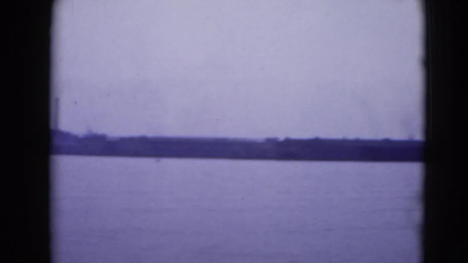 1940s home-movie view of open water and a distant Pennsylvania shoreline, seen through dark 8mm frame borders.