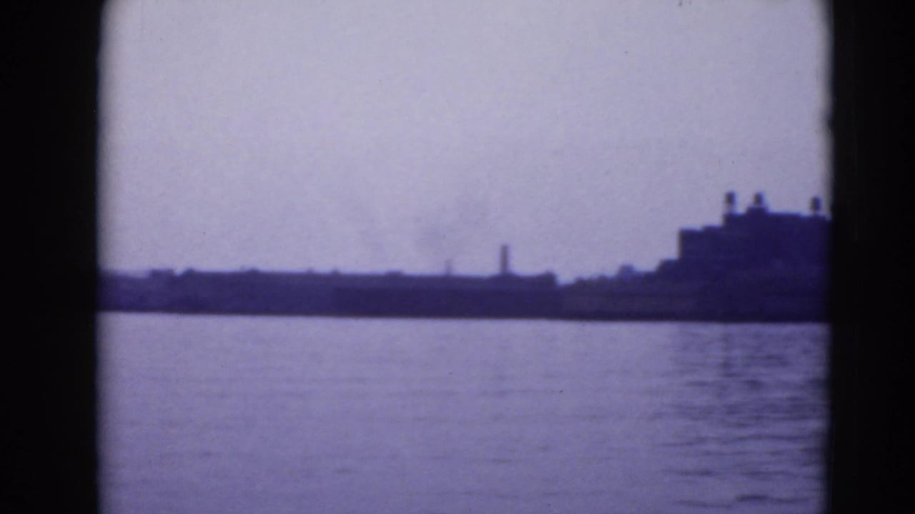 Distant Pennsylvania waterfront with open water, low shoreline structures, and a larger blocky building at the right edge.