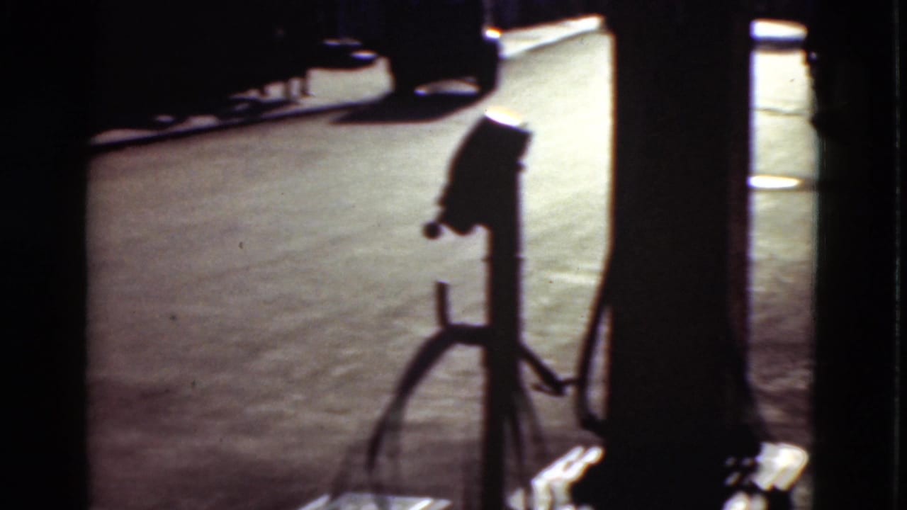 Gas pump silhouette beside a paved road with dark film frame edges.