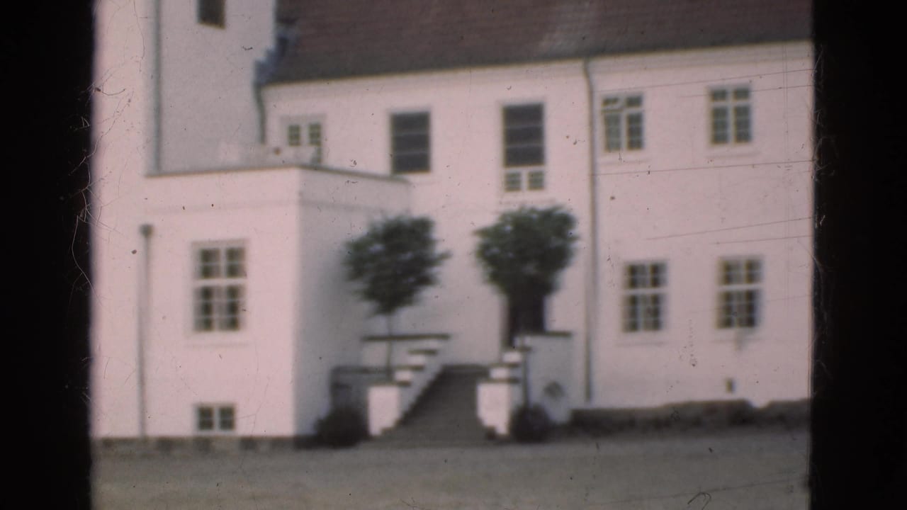 White multi-storey building with windows, stairs, small trees, and dark 8mm frame borders.