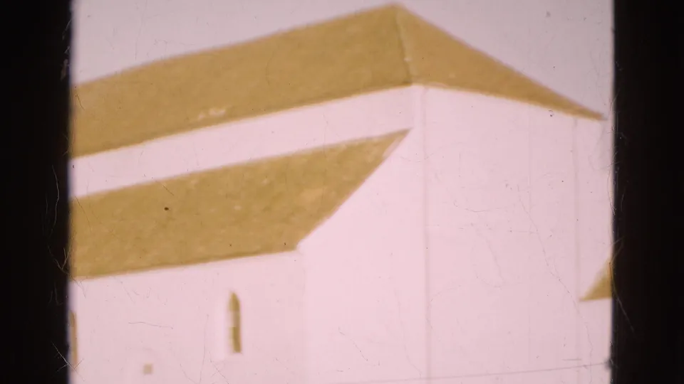 1975 Denmark home-movie frame with a white wall, brown roof edge, arched window and visible film gate border.