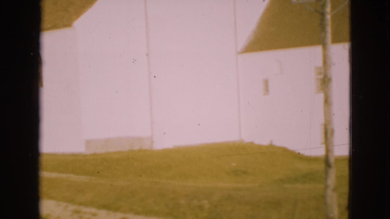 Soft 8mm frame of a bright white building wall in Denmark, partly blocked by a dark vertical window mullion.