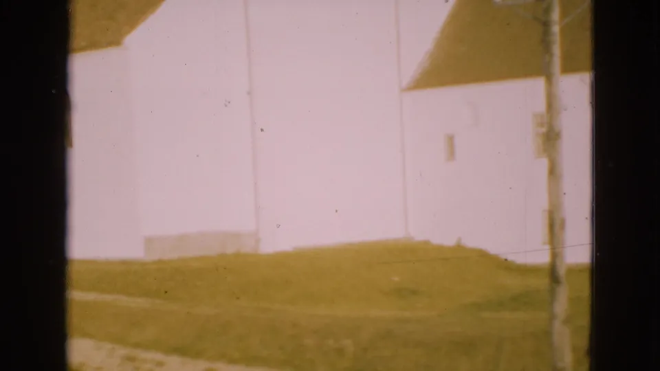 Soft 8mm frame of a bright white building wall in Denmark, partly blocked by a dark vertical window mullion.
