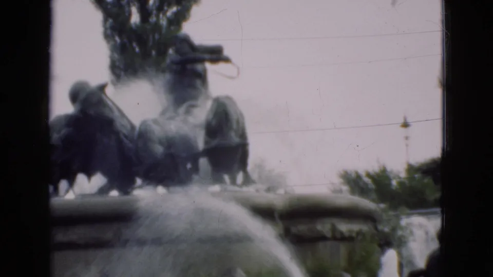 The 1975 Denmark home-movie frame shows the sculptural fountain from a visitor viewpoint, with water streaming across the foreground.