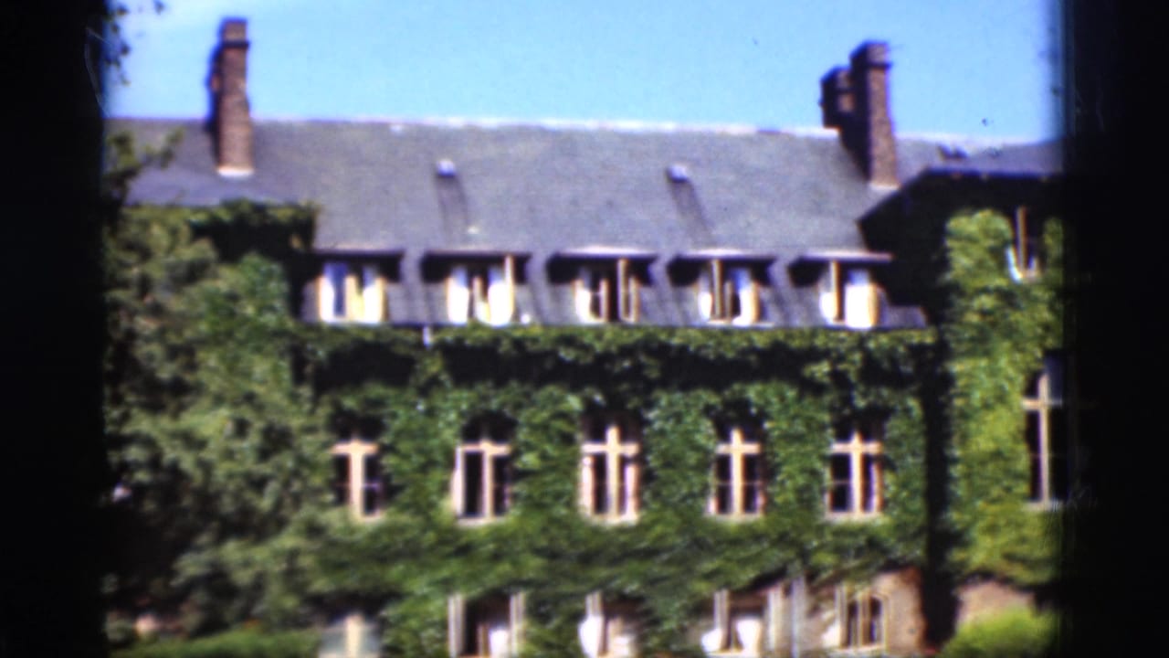 1975 Denmark 8mm frame showing a large ivy-covered house facade with tall windows, chimneys, roof dormers, and dark film-edge framing.