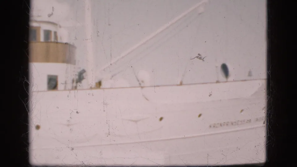 1975 Denmark home-movie frame showing the cream superstructure and white hull of Kronprinsessan Ingrid at harbor.