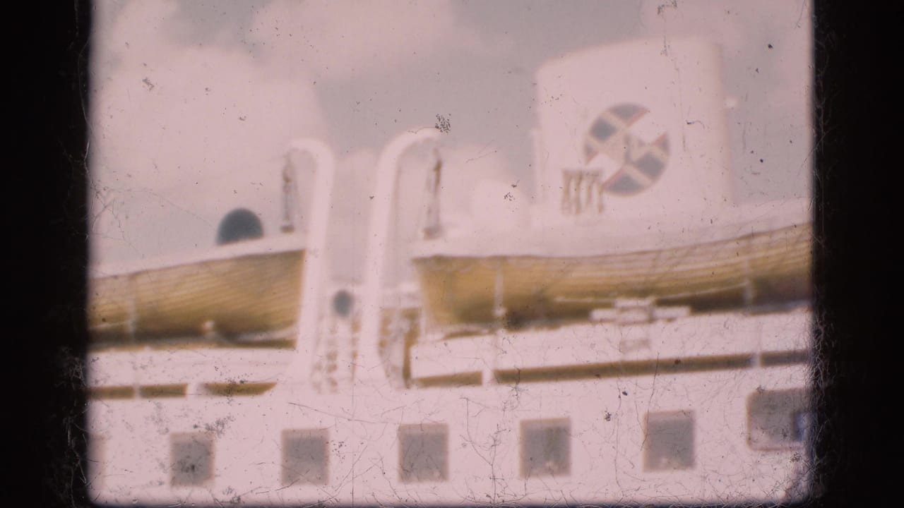 1975 Denmark home-movie frame showing a large white ferry side with lifeboats and a visible emblem, softened by faded 8mm exposure.