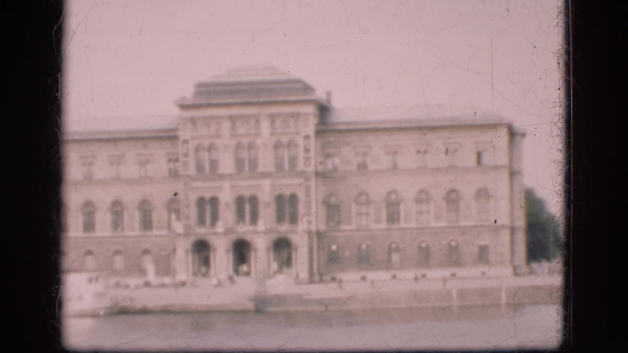 Faded 1975 Denmark 8mm frame showing a grand stone building with rows of windows and a broad foreground area.