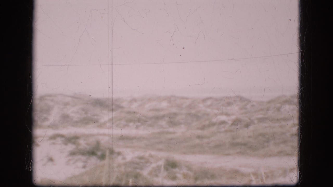 Soft 8mm view of a Danish barren landscape under cloud cover, with the horizon low and no people or structures visible.