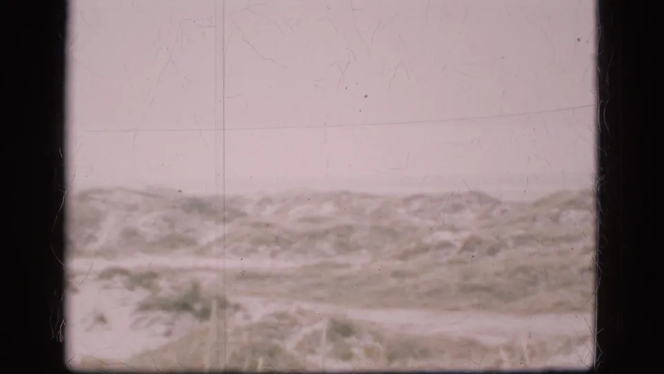 Soft 8mm view of a Danish barren landscape under cloud cover, with the horizon low and no people or structures visible.