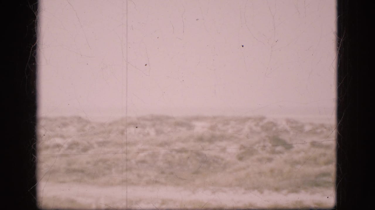 1975 Denmark 8mm view of a low windswept dune ridge beneath a pale sky, with soft focus, dust, scratches, and heavy frame borders.