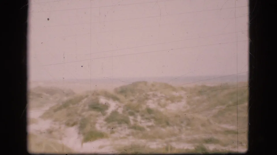 Faded 1975 Denmark frame with a sandy path cutting through low dunes toward the shoreline area.