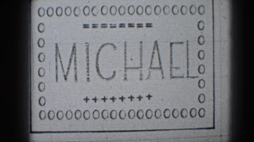 Late-1940s 8mm title card showing MICHAEL in large letters with punched-film-style decoration and soft scan edges.